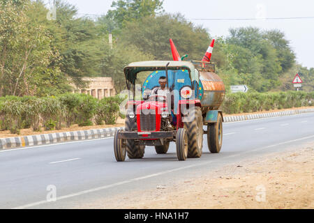 Rajasthan, India, 21 Gennaio 2017 - Un piccolo trattore-cisterna la guida verso il basso l'autostrada nazionale. Foto Stock