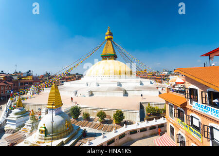 Kathmandu, Nepal - Ottobre 23, 2013: angolo di alta vista che circonda gli alberghi, ristoranti e negozi intorno Stupa Boudhanath sul cielo blu giorno Foto Stock