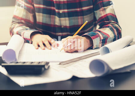 Costruzione ingegnere di lavoro sul progetto al suo luogo di lavoro in ufficio Foto Stock