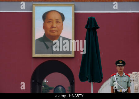 Un soldato sta di guardia, al di sotto di un ritratto del Presidente Mao Zedong, al di fuori di Tiananmen Gate (Porta della Pace Celeste) a Piazza Tiananmen a Pechino, Chi Foto Stock