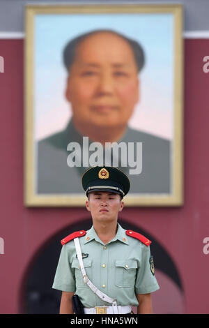 Un soldato sta di guardia, al di sotto di un ritratto del Presidente Mao Zedong, al di fuori di Tiananmen Gate (Porta della Pace Celeste) a Piazza Tiananmen a Pechino, Chi Foto Stock