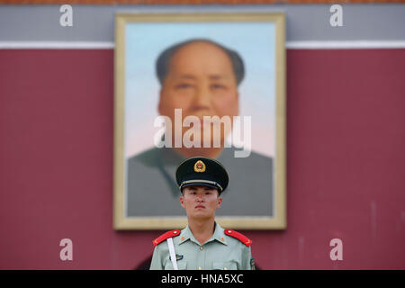 Un soldato sta di guardia, al di sotto di un ritratto del Presidente Mao Zedong, al di fuori di Tiananmen Gate (Porta della Pace Celeste) a Piazza Tiananmen a Pechino, Chi Foto Stock