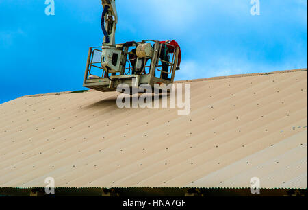 Le riparazioni del lavoratore coperchio di metallo su un piccolo cestino passeggero camion gru Foto Stock