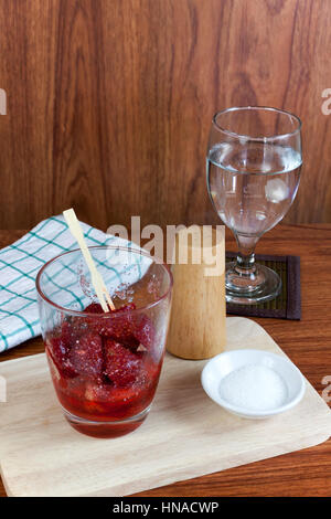 Split fresco Fragole mescolato con lo zucchero e il sale nel bicchiere di vetro. Snack di frutta cibo tailandese. Foto Stock