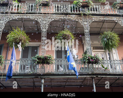 Soffiare bolle da un balcone ornato di New Orleans a Mardi Gras Foto Stock