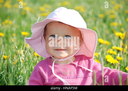 Kleines Maedchen, 1 Jahr, in Loewenzahnwiese - bambina in un prato di dente di leone Foto Stock