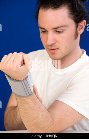 Mann misst Blutdruck - uomo con sangue ambulatoriale unità di pressione Foto Stock