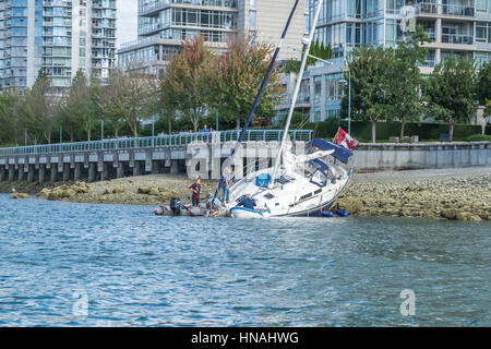 Una barca a vela arenata sulle rive di False Creek a Vancouver British Columbia. Foto Stock