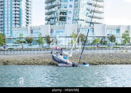 Una barca a vela spiaggiata sulle rive di False Creek a Vancouver British Columbia. Foto Stock