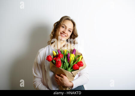 Felice ragazza con un mazzo di fiori colorati nelle loro mani. Concetto la Giornata internazionale della donna Foto Stock