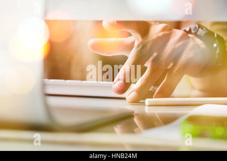 Imprenditore digitando su una tastiera al banco doppia esposizione Foto Stock