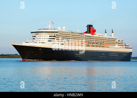 Stade, Germania - 30 agosto 2016: lussuosa nave da crociera RMS Queen Mary 2 partenza da Amburgo a Southampton sul fiume Elba in serata la luce del sole. Foto Stock