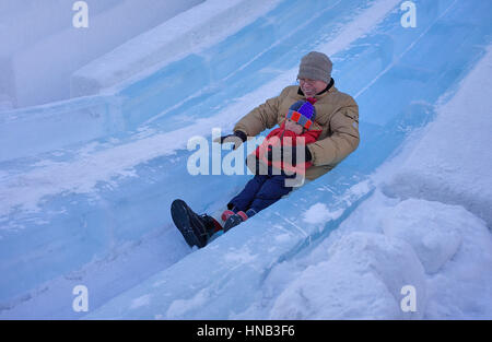 Il padre e il figlio lo scorrimento verso il basso una pendenza,Sapporo Snow Festival,snow sculpture,Parco Odori, Sapporo, Hokkaido, Giappone Foto Stock