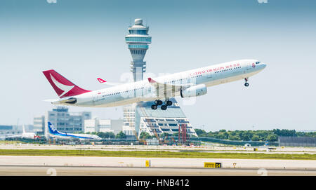 Un Cathay Dragon Airbus A330 decolla dall'Aeroporto Internazionale Pudong di Shanghai, con la torre di controllo in background. Foto Stock