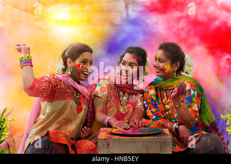 Tre adolescenti ragazze indiana celebra Holi festival con abiti tradizionali e ornamenti Foto Stock