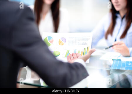 Imprenditore di puntamento a mano al documento grafico durante la discussione alla riunione. Foto Stock