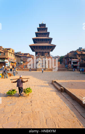 Bhaktapur, Nepal - 31 Ottobre 2013: Nepalese uomo che porta le verdure passato integre Pagoda Nyatapola in Bhaktapur Taumadhi piazza prima di Gorkha 2015 Foto Stock