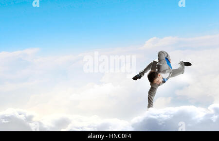 Giovane imprenditore allegro facendo handstand sul cloud Foto Stock