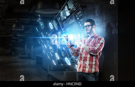 Hipster guy contro media technologies sfondo utilizzando dispositivo tablet pc. I supporti misti Foto Stock