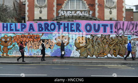 Bristol, Regno Unito. Xi Febbraio, 2017. La gente a piedi passato un muro di graffiti nel Stokes Croft area. Alcuni Bristol basati gli artisti di strada sono state nel corso dei colloqui con il Consiglio a designare gli spazi giuridici per la street art e graffiti in scia a Bristol sindaco di pulire le strade della campagna. Credito: 1000 parole/Alamy Live News. Foto Stock