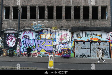 Bristol, Regno Unito. Xi Febbraio, 2017. La gente a piedi passato un muro di graffiti nel Stokes Croft area. Alcuni Bristol basati gli artisti di strada sono state nel corso dei colloqui con il Consiglio a designare gli spazi giuridici per la street art e graffiti in scia a Bristol sindaco di pulire le strade della campagna. Credito: 1000 parole/Alamy Live News. Foto Stock