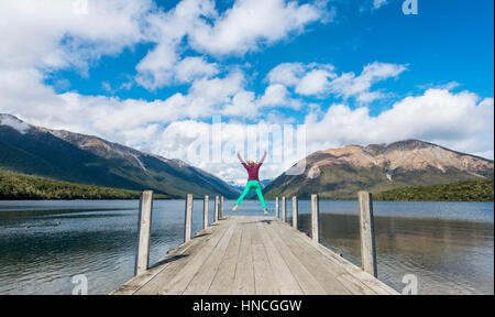 Donna di saltare in aria, dock sul Lago Rotoiti, Nelson Lakes National Park, Tasman District, Southland, Nuova Zelanda Foto Stock