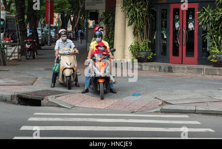 A Saigon, Vietnam, Nov 2016 - Tre passeggeri su uno scooter sul marciapiede per evitare il traffico nelle città di Ho Chi Minh. Foto Stock