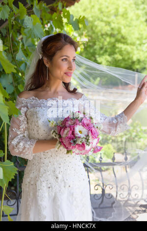 Straordinaria giovane sposa in posa di un verde giardino estivo Foto Stock