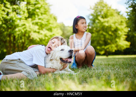 Bambino abbraccia il Golden Retriever cane con affetto e amore Foto Stock