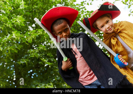 Due giovani bambini vestiti come cavalieri giocando come amici Foto Stock