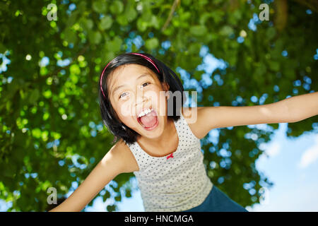 Felice ragazza asiatica apre la bocca con entusiasmo a ridere e ha divertimento Foto Stock
