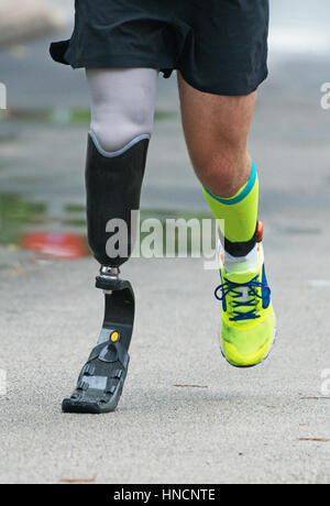 Running Man con gamba protesico su strada. Foto Stock