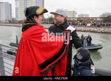 Marinaio britannico Alex Thomson (centro) e suo figlio Oscar sono accolti dal sindaco di Gosport Assessore Lynn gancio (sinistra) dopo aver preso parte ad una parata di vela come ha fatto il suo modo in Portsmouth Porto sul suo Hugo Boss barca dopo arrivando secondo nel Vendee Globe gara da solista. Foto Stock