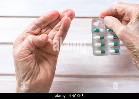 Senior donna mani prendendo la pillola dalla confezione Foto Stock