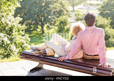 Di mezza età giovane relax su una panchina nel parco Foto Stock