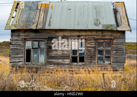 Legno vecchio decrepito shabby house che necessitano di riparazione con tetto danneggiato e finestre rotte Foto Stock