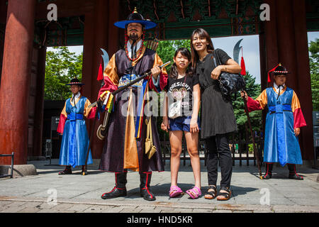 Protezioni cerimoniali e turisti presso il cancello del Palazzo Deoksugung, Seoul, Corea del Sud Foto Stock