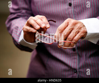 Le mani della donna anziana con artrite holding bicchieri Foto Stock