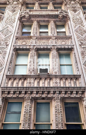 Sezioni di una terra cotta facciata in stile rinascimentale francese con elaborate decorazioni attorno alle finestre di un edificio nella città di New York Foto Stock