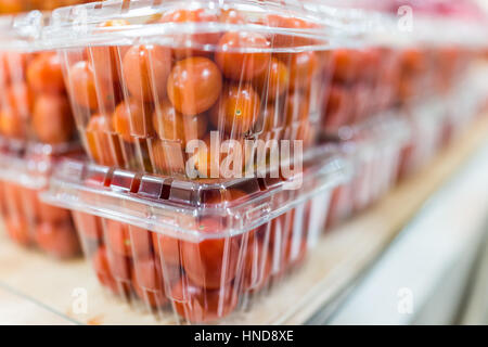 Pomodori ciliegia in scatole di plastica sul display Foto Stock