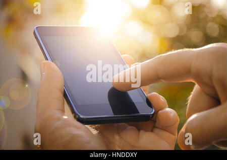 Mano d'uomo toccando schermo sul moderno mobile smart phone. Foto Stock