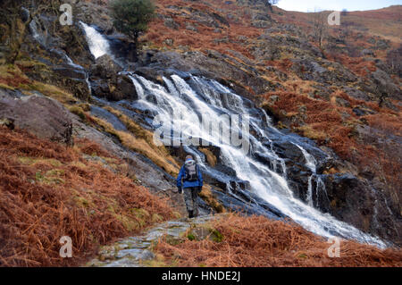 Lone Hill Walker nei pressi di latte acido Gill cascata in Seathwaite, Borrowdale,Parco Nazionale del Distretto dei Laghi, Cumbria, Regno Unito. Foto Stock