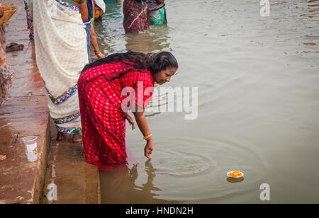 Donna che fa l'offerta, nel ghats del fiume Gange, Varanasi, Uttar Pradesh, India. Foto Stock