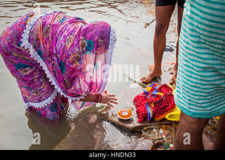 Donna che fa l'offerta, nel ghats del fiume Gange, Varanasi, Uttar Pradesh, India. Foto Stock