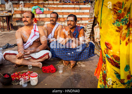 Pellegrini facendo una offerta rituale e pregare, ghats nel fiume Gange, Varanasi, Uttar Pradesh, India. Foto Stock