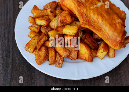 Grigliata di ali di pollo servito con patate fritte e lattuga Foto Stock