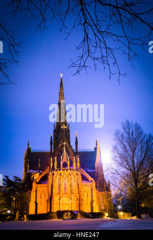 Bella cattedrale chiesa visibile su un inverno nevoso notte con luna incandescente in background Foto Stock