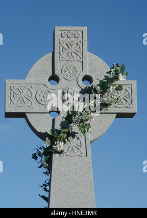 Memoriale della pasqua di artificiale giglio bianco corona sulla croce celtica grave headstone Foto Stock