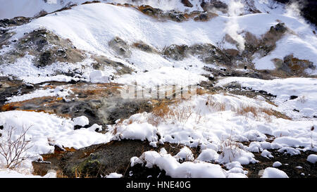 Primo piano in pietra la nebbia Noboribetsu Onsen neve invernale del parco nazionale di Jigokudani, Hokkaido, Giappone Foto Stock