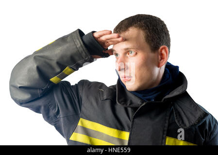 Vigile del fuoco in tuta protettiva guarda fuori nella distanza su uno sfondo bianco Foto Stock